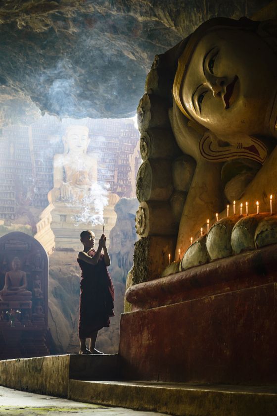 Asian monk lighting incense in temple